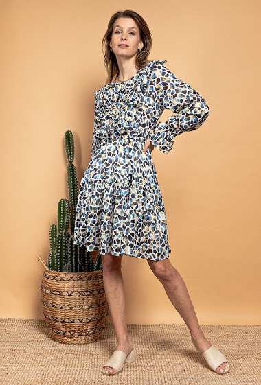 Patterned dress, shiny threads, long sleeves. The model measures 170 cm