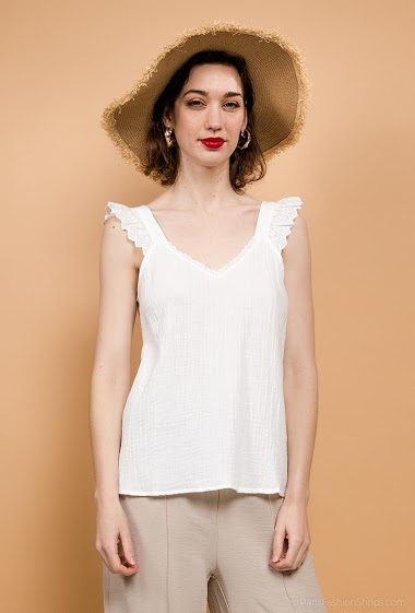 Tank top with embroidered and perforated straps, ruffles. The model measures 177 cm